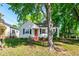 Charming single-story home with a bright red front door and mature trees in the front yard at 1003 E Club Blvd, Durham, NC 27704