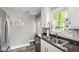 Well-lit kitchen featuring a stainless steel fridge, modern appliances, and a double bowl sink near a window at 1003 E Club Blvd, Durham, NC 27704