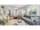 Comfortable living room featuring hardwood floors, a plush gray sofa, and abundant natural light at 1003 E Club Blvd, Durham, NC 27704