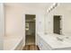 Clean, bright bathroom with a double sink vanity, bathtub, and a door leading to the bedroom at 1003 Walnut Dr, Erwin, NC 28339