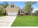 Charming home with a well-manicured lawn and attached two-car garage in a suburban neighborhood at 1003 Walnut Dr, Erwin, NC 28339