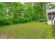 Serene backyard with lush green lawn and mature trees, offering a private retreat at 1007 Wellstone Cir, Apex, NC 27502