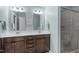 Bright bathroom featuring double sinks, a walk-in shower, and light blue walls at 1007 Wellstone Cir, Apex, NC 27502