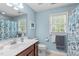 Bright bathroom with a single vanity, floral shower curtain and natural light at 1007 Wellstone Cir, Apex, NC 27502