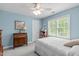 Light and airy bedroom painted a calming blue with a ceiling fan and natural lighting at 1007 Wellstone Cir, Apex, NC 27502