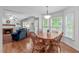Bright dining area adjacent to the living room with large windows and wood table at 1007 Wellstone Cir, Apex, NC 27502