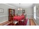Formal dining room with an elegant chandelier, hardwood floors, and a decorative hutch at 1007 Wellstone Cir, Apex, NC 27502