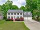 Traditional two-story home with attached two car garage, well-manicured lawn and colorful landscaping at 1007 Wellstone Cir, Apex, NC 27502