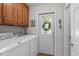 Laundry room with washer, dryer, cabinets, decor, and an exterior door at 1007 Wellstone Cir, Apex, NC 27502