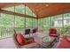 Inviting screened porch featuring wood ceiling, comfortable seating, and views of the private backyard at 1007 Wellstone Cir, Apex, NC 27502