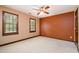 Bedroom featuring two windows, a ceiling fan, tan walls and a orange accent wall at 103 Donna Pl, Cary, NC 27513