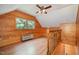 Cozy bonus room with wood-paneled walls, hardwood floors, and natural light from the large windows at 103 Donna Pl, Cary, NC 27513