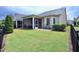 Spacious backyard with a screened porch, green grass, and black metal fencing at 1033 Cuthbert Ln, Durham, NC 27703