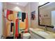 This bathroom has a retro vibe with colorful art, a fun shower curtain, and a granite vanity at 1033 Cuthbert Ln, Durham, NC 27703