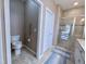 Featuring a toilet with a grab bar, a shower, tiled floors, and access to a white door at 1033 Cuthbert Ln, Durham, NC 27703
