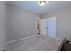 An empty bedroom with tan walls, neutral carpet, a closet and white doors at 1033 Cuthbert Ln, Durham, NC 27703