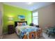 Bedroom with vibrant green walls, patterned bedding, and unique decor, creating a cheerful space at 1033 Cuthbert Ln, Durham, NC 27703