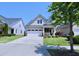 Charming home featuring a two-car garage, lovely front porch, and well-manicured lawn at 1033 Cuthbert Ln, Durham, NC 27703