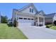 Home's exterior featuring a two-car garage and a meticulously maintained lawn at 1033 Cuthbert Ln, Durham, NC 27703