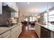 Open-concept kitchen showcases stone countertops, stainless appliances, and seamless flow into dining, living spaces at 1033 Cuthbert Ln, Durham, NC 27703