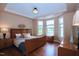 This main bedroom features a tray ceiling, a decorative light fixture, and multiple windows at 1033 Cuthbert Ln, Durham, NC 27703