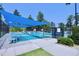 A fenced tennis court with a blue awning and benches provides residents a place to exercise and socialize at 1033 Cuthbert Ln, Durham, NC 27703