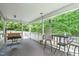 Spacious covered back porch with wood floors, comfortable seating, and a serene view of the surrounding greenery at 108 Christy Circle Ln, Clayton, NC 27520