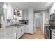 Well-lit kitchen boasts white cabinets, stainless steel appliances, granite countertops, and hardwood floors at 108 Christy Circle Ln, Clayton, NC 27520