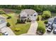 Stunning aerial view of home showcasing the well-manicured lawn, mature trees and circular driveway at 108 Yosemite Ct, Holly Springs, NC 27540