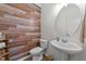Half bathroom showcasing shiplap accent wall, pedestal sink, and decorative mirror at 108 Yosemite Ct, Holly Springs, NC 27540