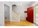 Welcoming foyer with hardwood floors, staircase and red front door at 1097 Trentini Ave, Wake Forest, NC 27587