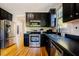 Modern kitchen with stainless steel appliances, dark cabinets, and hardwood floors at 1097 Trentini Ave, Wake Forest, NC 27587