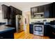 Modern kitchen with stainless steel appliances, dark cabinets, and hardwood floors at 1097 Trentini Ave, Wake Forest, NC 27587