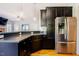 Well-appointed kitchen with stainless steel appliances, dark cabinets, and hardwood floors at 1097 Trentini Ave, Wake Forest, NC 27587