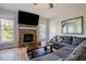 Cozy living room featuring a stone fireplace, large TV, comfortable sofa, and hardwood floors at 1097 Trentini Ave, Wake Forest, NC 27587