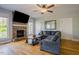 Comfortable living room featuring a stone fireplace, large TV, hardwood floors, and a modern ceiling fan at 1097 Trentini Ave, Wake Forest, NC 27587