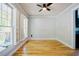 Bright living room featuring hardwood floors, ceiling fan, and large windows at 1097 Trentini Ave, Wake Forest, NC 27587
