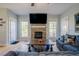 Open living room featuring a stone fireplace, large TV, comfortable sofa, and hardwood floors at 1097 Trentini Ave, Wake Forest, NC 27587