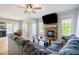 Cozy living room featuring a stone fireplace, large windows, and comfortable seating for relaxation and entertaining at 1097 Trentini Ave, Wake Forest, NC 27587