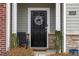 Close-up of a front door entrance with a wreath, seating, and decorative details at 1109 Banworth Ct, Mebane, NC 27302