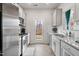Well-lit kitchen with stainless steel appliances, white cabinets and a view to the backyard at 1109 Banworth Ct, Mebane, NC 27302