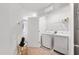 Functional laundry room with white washer, dryer, and wire shelving for storage at 1109 Banworth Ct, Mebane, NC 27302