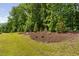 Well-maintained backyard landscape with lush green grass and mulch beds at 1129 Santa Cruz St, Wake Forest, NC 27587