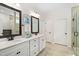 Bright bathroom featuring dual sinks with white cabinets and a tiled shower at 1129 Santa Cruz St, Wake Forest, NC 27587