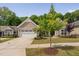 Inviting single-story home featuring a well-manicured lawn, charming landscaping and an attached two-car garage at 1129 Santa Cruz St, Wake Forest, NC 27587