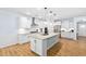 A sprawling kitchen features a large granite island, stainless steel appliances, and pristine white cabinets at 1129 Santa Cruz St, Wake Forest, NC 27587
