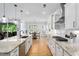 A gorgeous kitchen includes a view to the breakfast area, granite countertops, stainless appliances and bright lighting at 1129 Santa Cruz St, Wake Forest, NC 27587