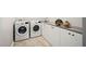 Well-equipped laundry room featuring a modern washer, dryer, and ample storage cabinets with a sleek countertop at 1129 Santa Cruz St, Wake Forest, NC 27587