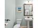 Light blue powder room featuring a pedestal sink, toilet, and artwork on the wall at 1129 Santa Cruz St, Wake Forest, NC 27587