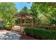 Charming backyard patio has a beautiful pergola, landscaping, and leads to a stone walkway at 1141 Brookhill Way, Cary, NC 27519
